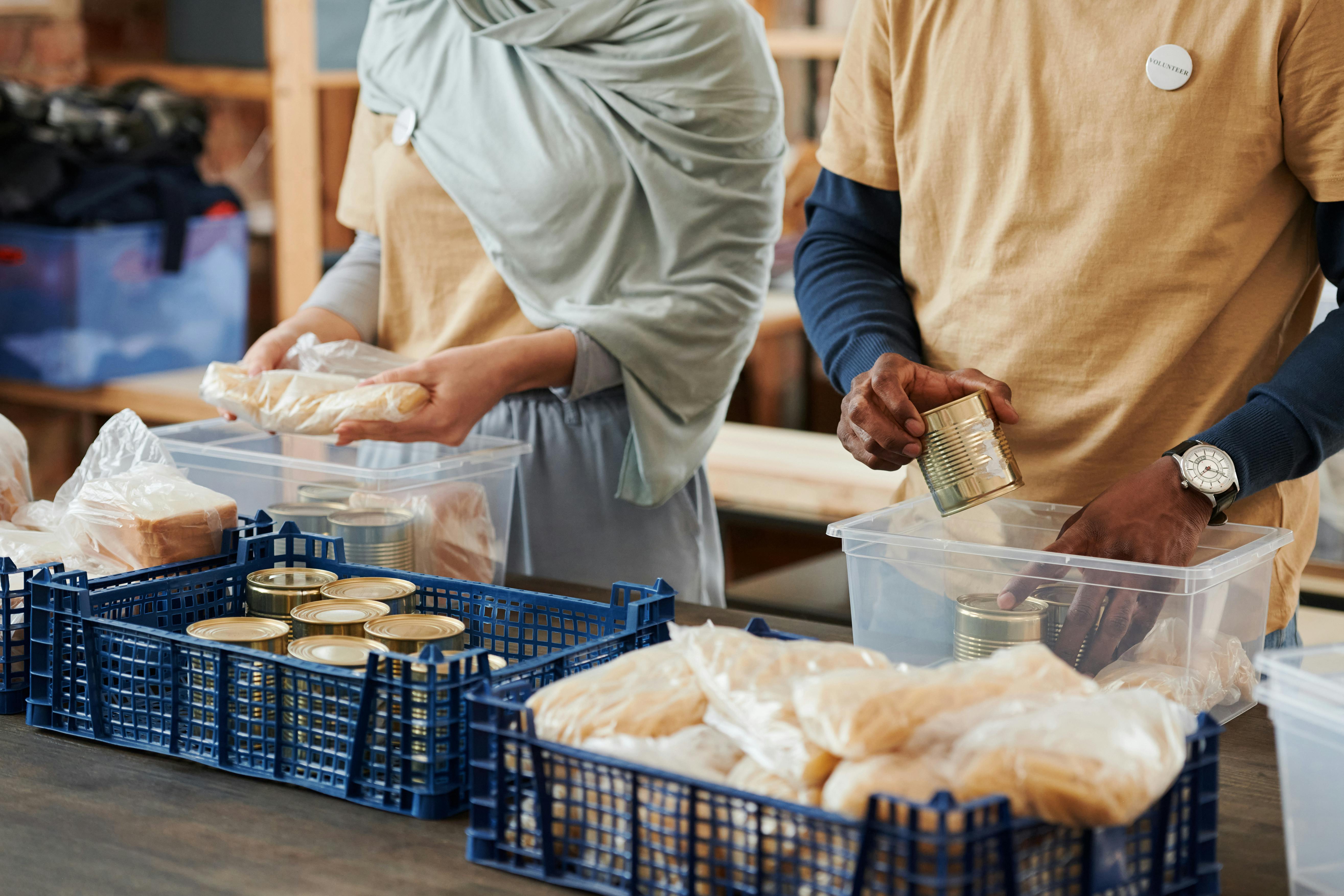 image of volunteers packing a box with canned goods