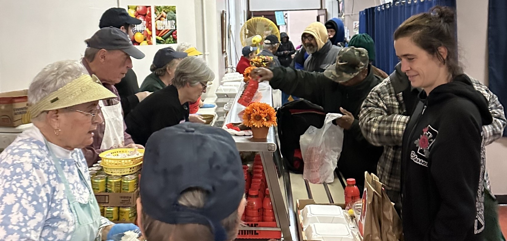 image of volunteers packing a box with canned goods