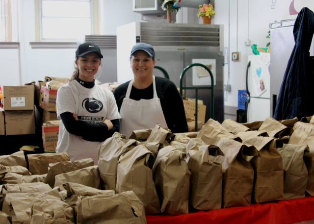 image of volunteers packing a box with canned goods